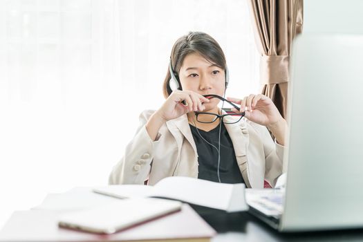 Teenage girl short hair in smart casual wear working on laptop while sit near window at home office