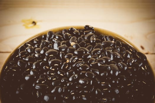 red  beans on wood background - soft focus with vintage film filter