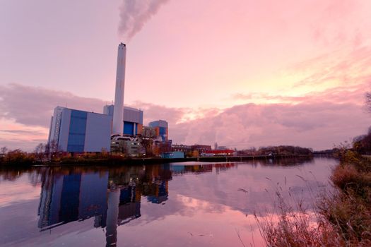 Building complex of modern waste-to-energy facility mirrored on water surface of Rhein-Herne-Kanal in Oberhausen, Germany, Europe