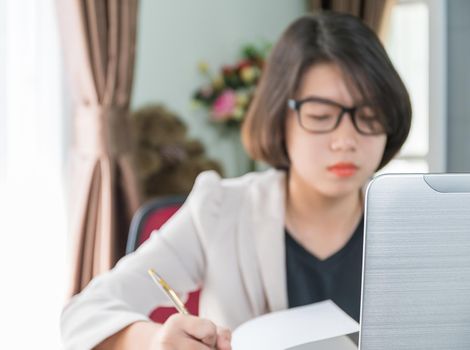 Teenage girl short hair in smart casual wear working on laptop while sit near window in home office