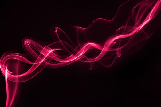 Pink smoke isolated on black background.