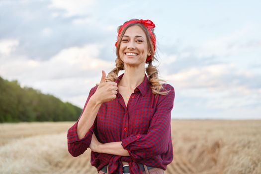 Woman farmer standing farmland smiling Female agronomist specialist farming agribusiness Happy positive caucasian worker agricultural field dressed red checkered shirt and bandana showing thumb up