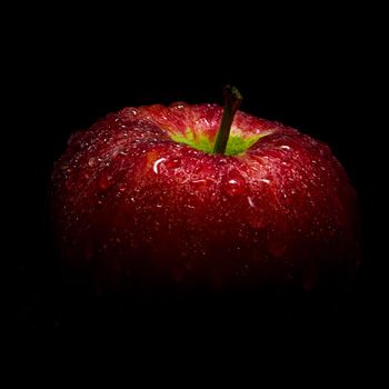 Close-up of Water droplet on glossy surface of freshness red apple on black background