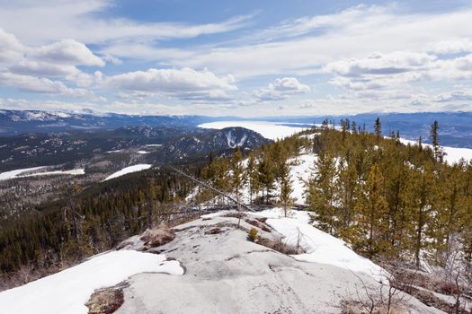 Boreal forest taiga wilderness with still frozen ice surface of Lake Laberge end of April at spring time in the Yukon Territory, Canada