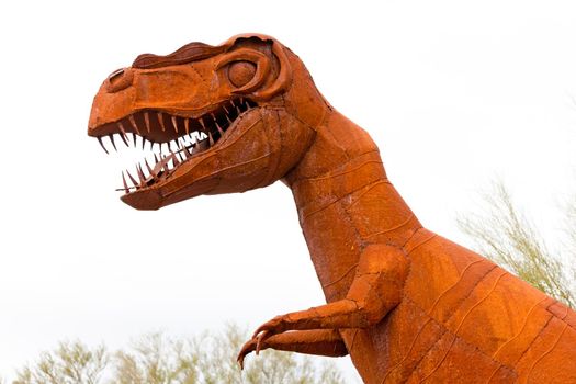 Tyrannus Saurus Rex dinosaur rusty iron sheet metal model looking dangerous on white background