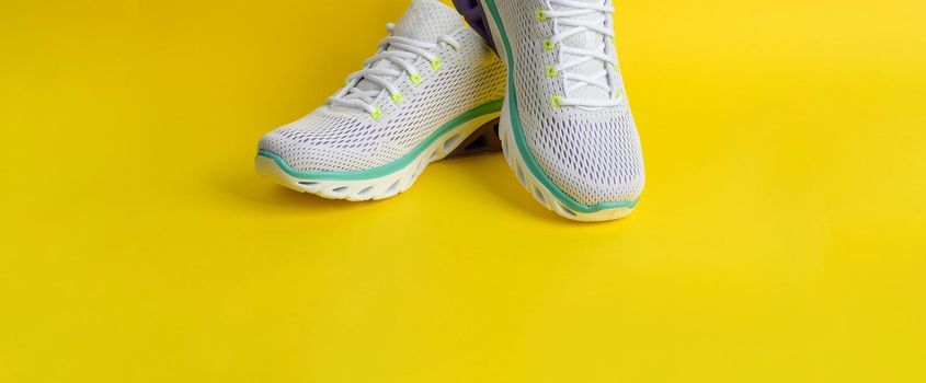 white women's sneakers with laces on a yellow background, banner