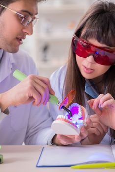 Doctor explaining to assistant how to use ultraviolet gun