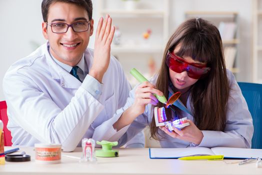 Doctor explaining to assistant how to use ultraviolet gun