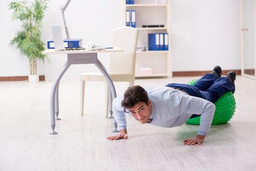 Employee exercising with swiss ball during lunch break