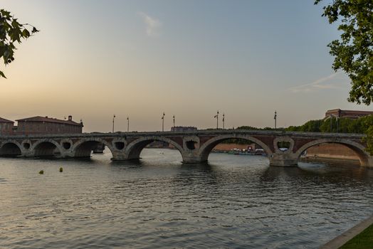 Sunset in the Garonne river and its bridges in Toulouse in Haute-Garonne, Occitania, France.