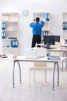 Handsome businessman employee sitting at his desk in office
