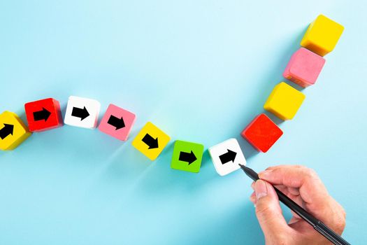 Businessman drawing an arrow on wooden block. Path for business growth success process concept.