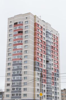 High-rise new building with gray and red balconies. Modern new buildings, building facades. Real estate and urban architecture concept.