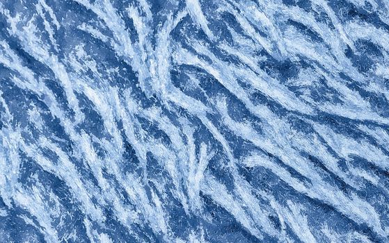 Blue frost pattern on a window glass in the winter. Abstract winter background