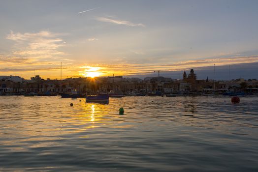 Traditional eyed colorful boats Luzzu in the Harbor of Mediterranean fishing village Marsaxlokk, Malta