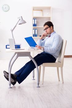 Young handsome businessman employee working in office at desk