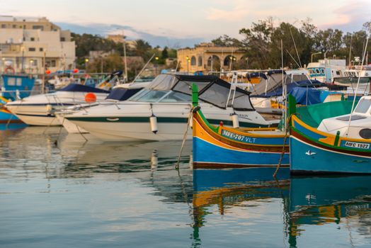 Traditional eyed colorful boats Luzzu in the Harbor of Mediterranean fishing village Marsaxlokk, Malta