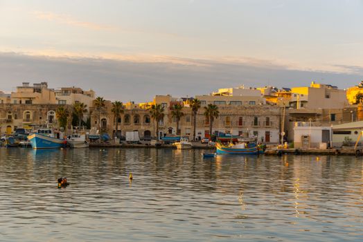 Traditional eyed colorful boats Luzzu in the Harbor of Mediterranean fishing village Marsaxlokk, Malta