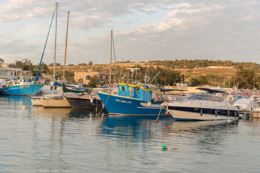 Traditional eyed colorful boats Luzzu in the Harbor of Mediterranean fishing village Marsaxlokk, Malta
