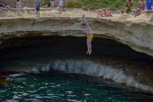 People are enjoying sunny day at Saint Peter's pool near Marsaxlokk, Malta