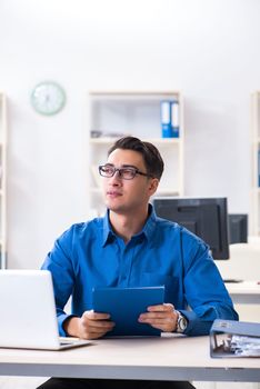 Handsome businessman employee sitting at his desk in office