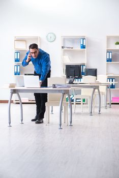 Handsome businessman employee sitting at his desk in office