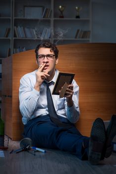 Sad employee in office missing his wife after divorce separation