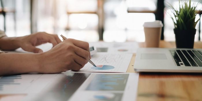 Close Up Of A Businessman Holding Graph Paper And Pen.