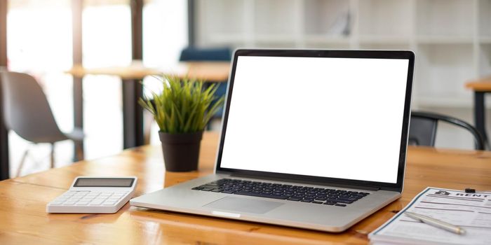 Blank screen Laptop computer and poster workspace background in modern office.