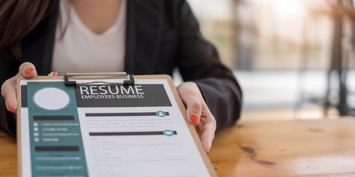 Businesswoman submits resume employer to review job application information on the desk, presents the ability for the company to agree with the position of the job..