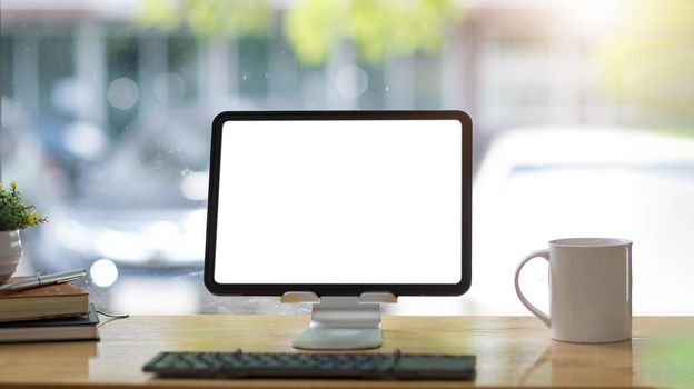 Blank screen Laptop computer and poster workspace background in modern office.