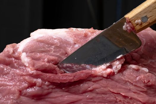 Slice the pork or beef with a knife on the table in close-up.Preparation of meat dishes and food products.Pieces of red meat for shish kebab,barbecue or kebab.Raw fresh meat is cut with a knife.recipe