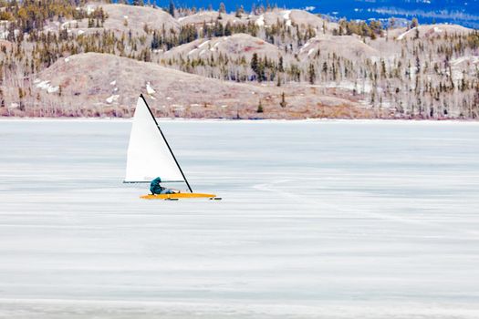 Sailing an ice-boat on ice surface of frozen Lake Laberge, Yukon Territory, Canada, driven on metal runner skids