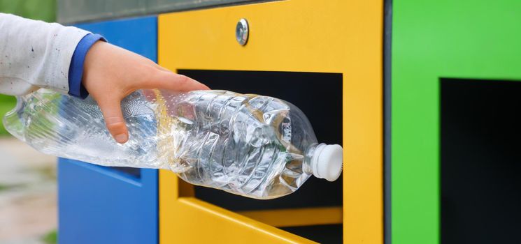 Bin. Child hand throwing plastic bottle recycling container garbage sorting rubbish collection bin. Close up hand put bottle plastic trash can. Child trash recycle bin. Kid recycle plastic garbage can