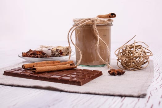 brown detox coctail with cinnamon sticks and chocolate lie on the table