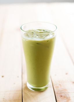 iced matcha latte on wood background