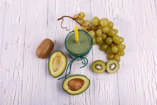 healthy smoothie with grape,avocado and kiwi lie on the table