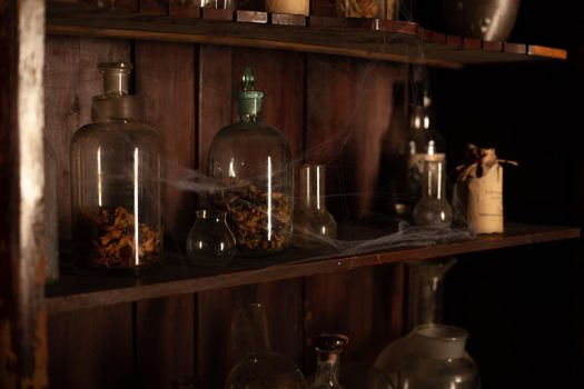 Halloween background Shelves with alchemy tools Skull spiderweb bottle with poison candles Witcher workspace Scarry room