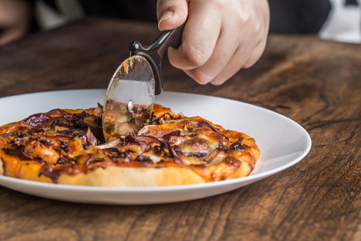 Chef cuts freshly prepared pizza slices