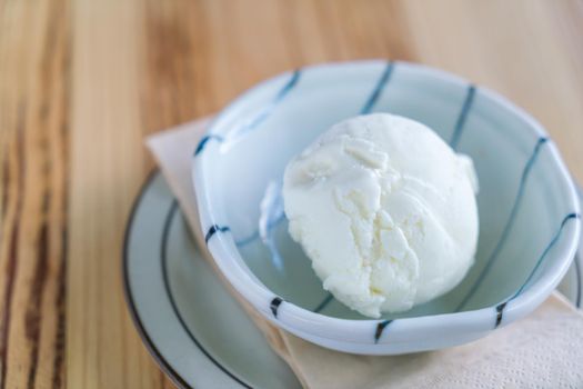 Milk ice cream in bowl on wood table