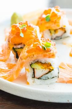 Selective focus point on grilled salmon sushi roll in white plate - Japanese food style