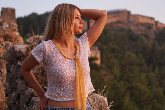 Beautiful girl at sunset. Ancient castle on the background. Alania Turkey. Tourism concept