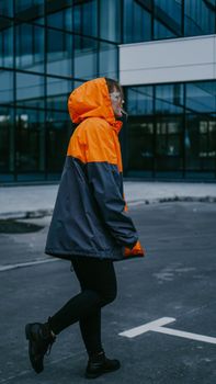 Girl in orange protective overalls and glasses. Air pollution and hazard concept