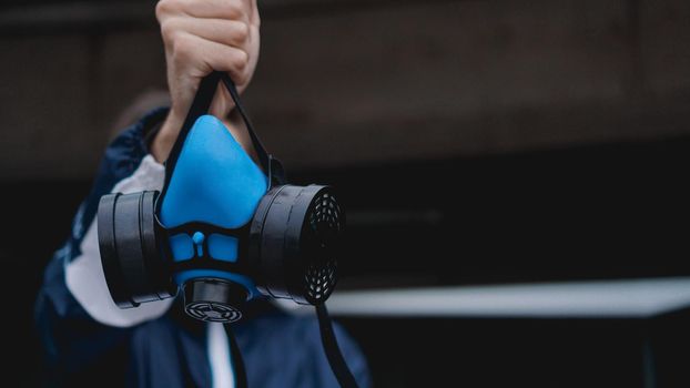 Protection respirator half mask for toxic gas.The man prepare to wear protection air pollution. Man holds a respirator, arm extended forward