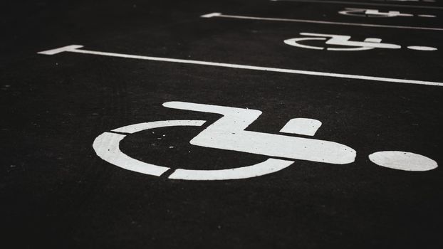 Parking place sign for disabled on grey dark brick