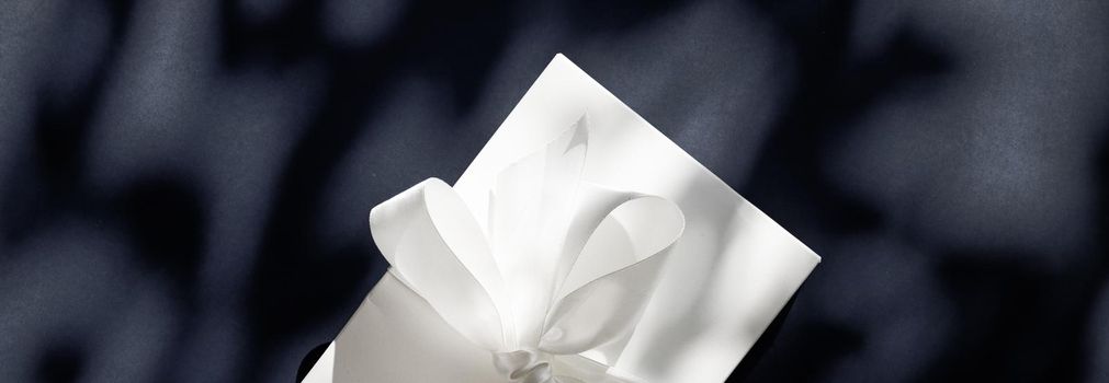 Anniversary celebration, shop sale promotion and luxe surprise concept - Luxury holiday white gift box with silk ribbon and bow on black background, luxe wedding or birthday present