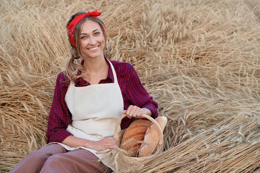 Female farmer sitting wheat agricultural field Woman baker holding wicker basket bread eco product Baking small business Caucasian person dressed red plaid shirt apron organic healthy food