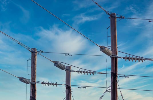 Photograph of a wooden telephone post and cables against a blue sky