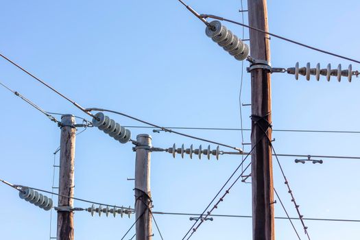 Photograph of a wooden telephone post and cables against a blue sky