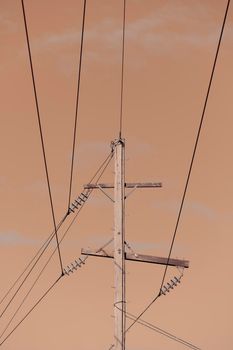 Photograph of a wooden telephone post and cables against a blue sky